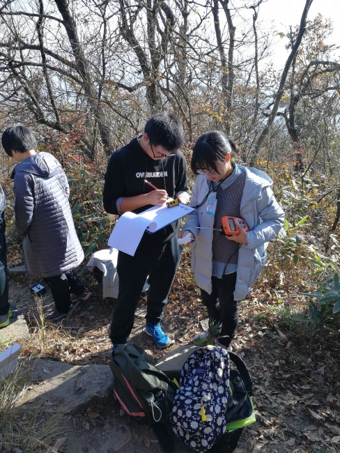 员工沿着登山路径测量各种基本生态环境参数，观测植被垂直梯度